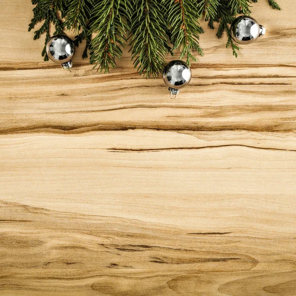 Shiny glowing small baubles on a flat wooden background. Glimmering, shimmering winter christmas background. Space for advertising products, decorations and text.
