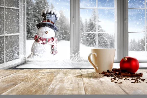白い雪の冬の背景と帽子とスカーフで小さな笑顔の雪だるま あなたの製品や装飾のためのスペース クリスマスの時間に窓の外の雪で覆われた木々の鮮やかな風景 — ストック写真