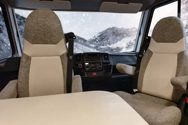 Car Camper travel in winter time. Interior of camper with big window winter view. Empty space for your decoration.Cold december day and landscape of mountains. Snowy winter mountain background. Beautiful top view of Alps in Austria.