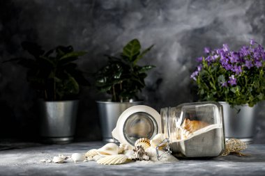 Arkaplanda boşluk ve camda kum olan kabuklar var. Bitki dekorasyonu ve karanlık ruh hali fotoğrafı.. 