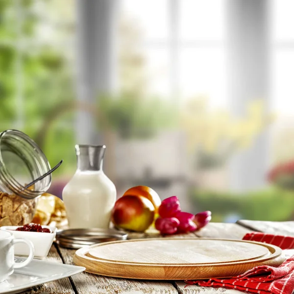 木のテーブルの背景と窓の外の日当たりの良い春のぼやけた景色とキッチンインテリア — ストック写真