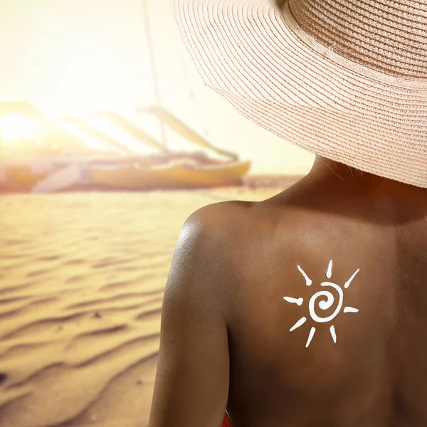 Woman with sun cream on her back and summer beach background. Space for your decoration or product.