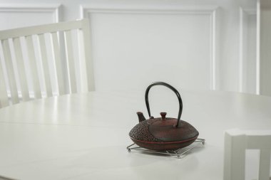 Arka planda çaydanlık olan boş beyaz masa. Beyaz Fransız duvarı..