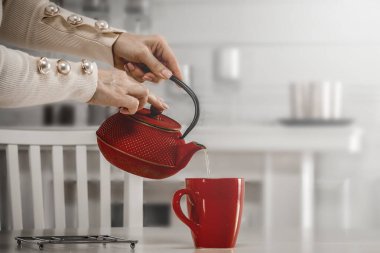 Kadın çaydanlığa sıcak çay dolduruyor, yakın plan. Metin için boşluk