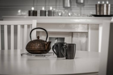 Beyaz mutfak iç kısmının arka planında sıcak çaydanlık ile wihite masa üzerinde