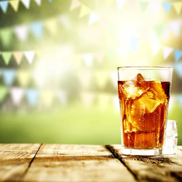 Ice tea in big glass with ice and fruit. Cold drink with blurred background.