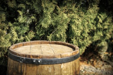 Eski ahşap fıçı, reklam ürünleri için boş bir masa. Yeşil bitkilerin arka planı. 