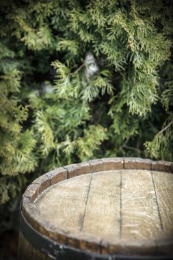 Eski ahşap fıçı, reklam ürünleri için boş bir masa. Yeşil bitkilerin arka planı. 