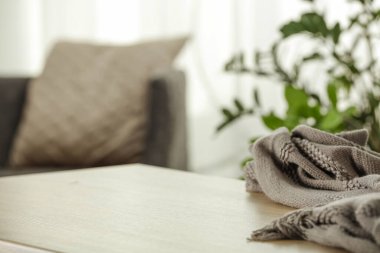 Evin arka planında bulanık olan ürünler için beyaz masa. Saksı bitkisi.