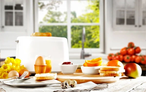 キッチンテーブルと朝の日差しの窓の背景に朝食 イースターの時間だ 窓空間の背景のぼやけ — ストック写真