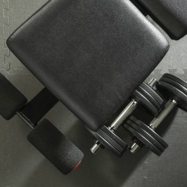 Aptal, halter ve spor salonu tezgahı. Spor salonunda idman. Ürünler ve dekorasyonlar için veya bulanık spor salonu arka planına sahip metin için boşluk.