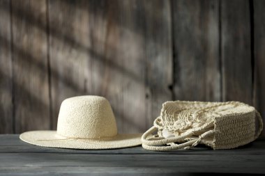 Dekorasyonun için ahşap masa. Hasır torba ve ahşap retro duvarlı şapka ve güneş ışığının gölgesi. Dekorasyonunuz için alanı kopyalayın. 