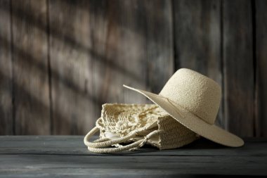 Dekorasyonun için ahşap masa. Hasır torba ve ahşap retro duvarlı şapka ve güneş ışığının gölgesi. Dekorasyonunuz için alanı kopyalayın. 