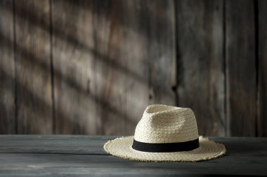 Dekorasyonun için ahşap masa. Ahşap retro duvarlı hasır şapka ve güneş ışığının gölgesi. Dekorasyonunuz için alanı kopyalayın. 