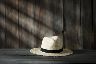 Dekorasyonun için ahşap masa. Ahşap retro duvarlı hasır şapka ve güneş ışığının gölgesi. Dekorasyonunuz için alanı kopyalayın. 