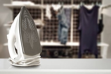 Masada ütü, bulanık kıyafetler ve çamaşır odası arka tarafta. Reklam için alan.