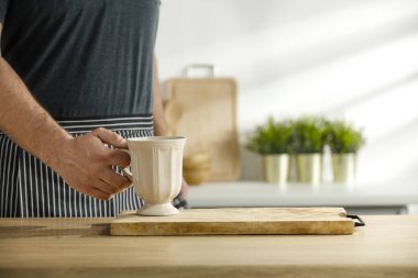 Masa arkası ve mutfakta bir erkek eli.