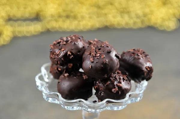 Handmade chocolate candies close-up.  In the background are golden beads.  Macro shot.