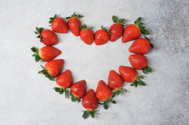  Masanın üzerindeki çilekler kalp şeklini oluşturur. Yukarıdan bak. Yakın plan. Hafif arkaplan. 