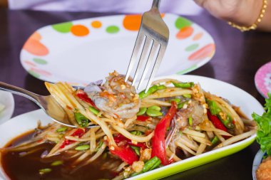 Papaya salatası yemek için çatalı tutan el. Papaya salatası. Geleneksel baharatlı Tayland yemeği, papaya salatası yemek.