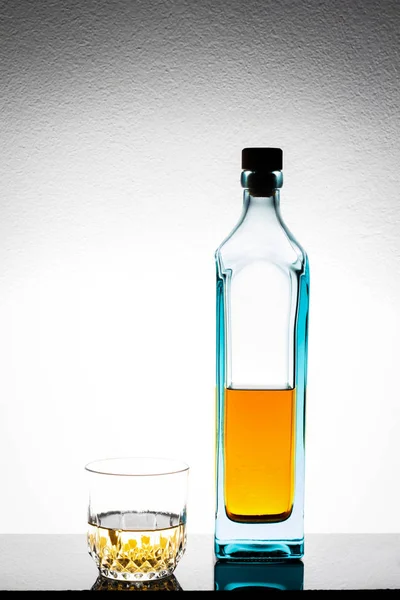 Бутылка Стакан Алкоголя Столе Белом Фоне Цементной Стены — стоковое фото