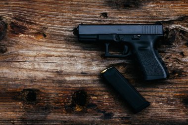 Eski ahşap arka planda cephanesi olan 9 mm 'lik bir silah. en üstteki görünüm
