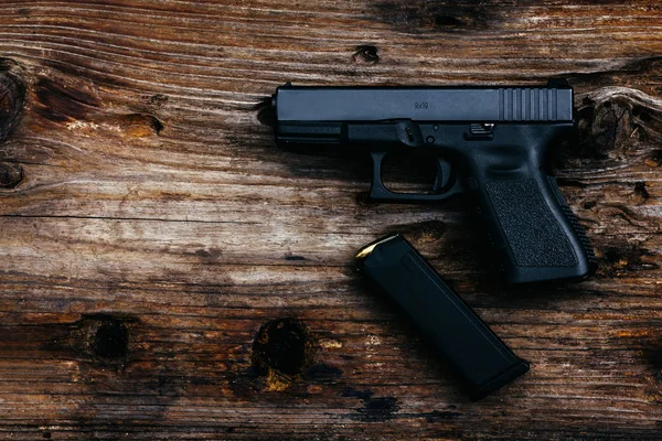 Eski ahşap arka planda cephanesi olan 9 mm 'lik bir silah. en üstteki görünüm