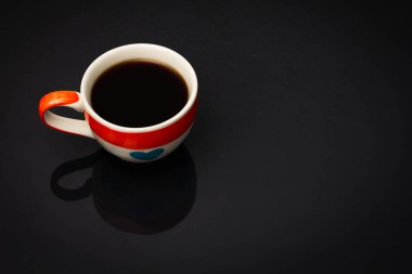 Kalp desenli kahve fincanı fincanda siyah kahve var.