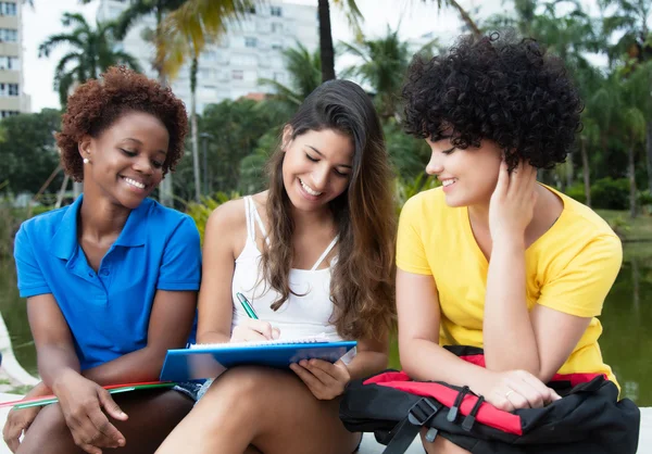 Três estudantes rindo do sexo feminino aprendendo ao ar livre — Fotografia de Stock