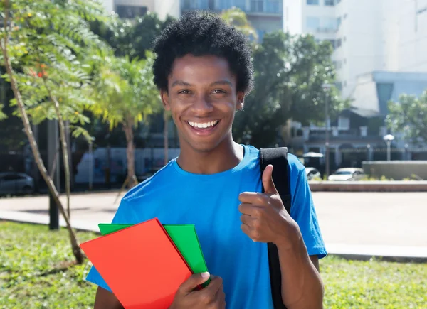 Joven afroamericano estudiante masculino mostrando el pulgar — Foto de Stock