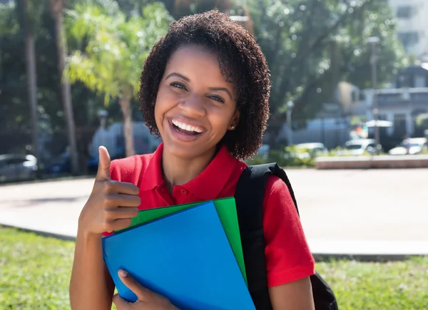 African american kvinnlig student visar tummen — Stockfoto