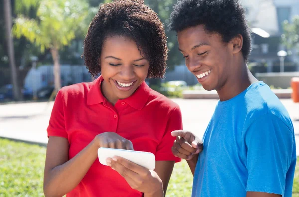 Два африканских американских молодых человека смотрят в телефон — стоковое фото