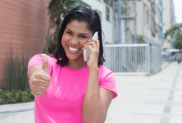 美洲印第安妇女在电话显示拇指在城市 — 图库照片