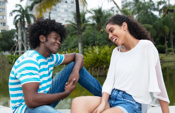 Latinsk kvinna flirta med afroamerikanska man — Stockfoto