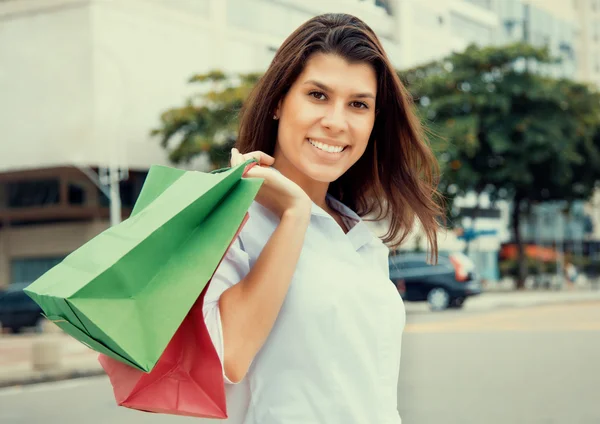 Happy woman with shopping bags in city in vintage cinema look — Stock Photo, Image