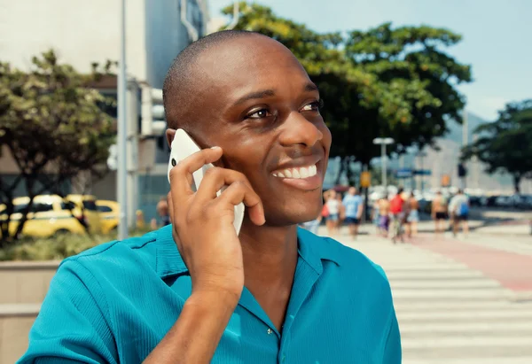 African american man met behulp van mobiele telefoon in een warme bioscoop-look — Stockfoto