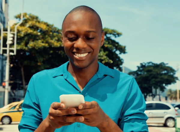 Αφρικανική αμερικανική άνθρωπος σερφάρισμα στο internet μέσω τηλεφώνου που είναι εξωτερική στο ένα — Φωτογραφία Αρχείου
