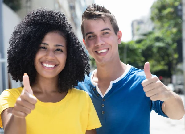 Laughing latin woman with curly black hair and boyfriend showing — Stock Photo, Image