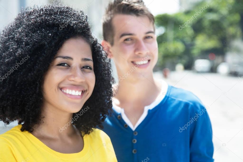 Laughing latin woman with curly black hair and boyfriend