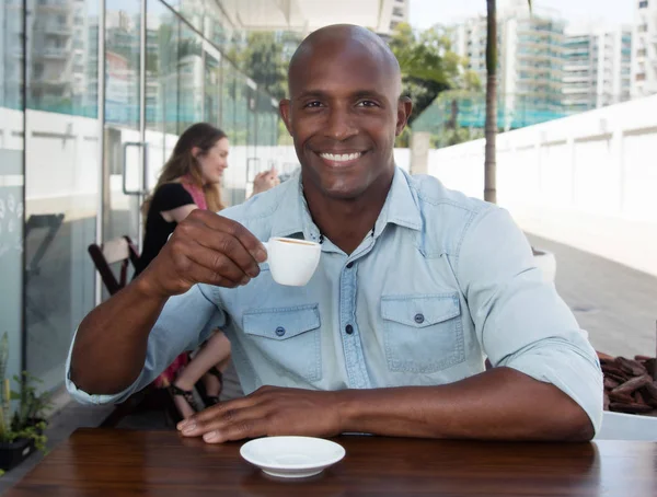 Hombre africano disfrutando de una taza de café en un restaurante — Foto de Stock