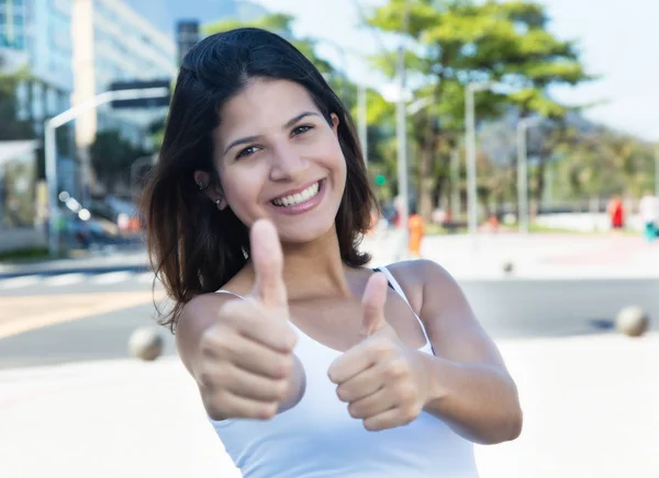 Mulher caucasiana feliz mostrando ambos os polegares na cidade — Fotografia de Stock