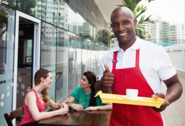 Bir restoranda iş yerinde yakışıklı Afro-Amerikan garson