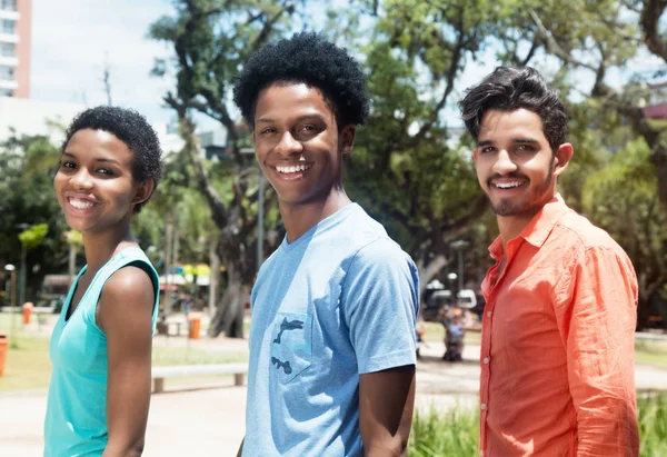 Grupa trzech szczęśliwy Ameryki Łacińskiej młodych ludzi w mieście — Zdjęcie stockowe