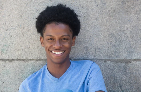 Afrikanischer junger Erwachsener mit Mauer im Hintergrund — Stockfoto