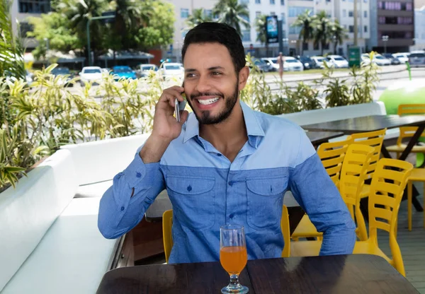 Riéndose hombre caucásico hablando en el teléfono celular en el restaurante — Foto de Stock