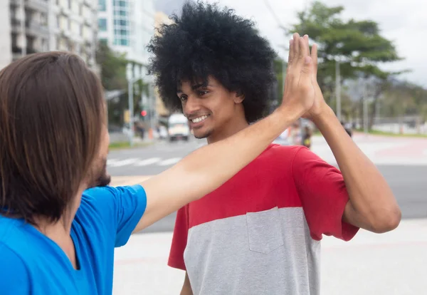 Afroamericano uomo dare alto cinque per un caucasico amico — Foto Stock