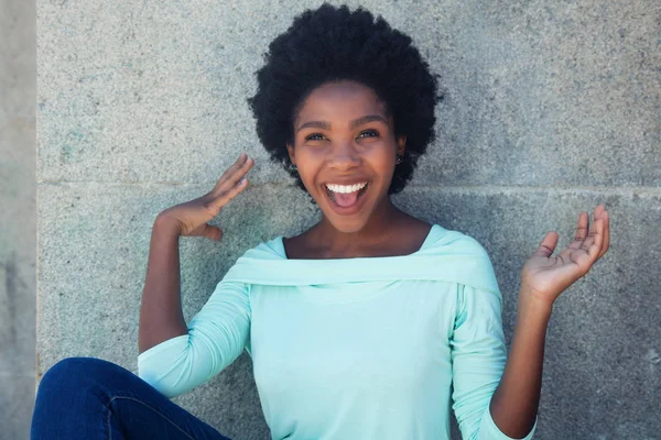 Animando a la mujer afroamericana con una camisa verde claro —  Fotos de Stock