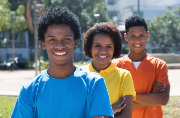 Grupo de tres adultos jóvenes afroamericanos riendo con cruz —  Fotos de Stock