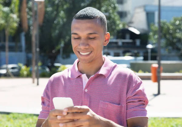 Handsome young mexican man messaging by phone