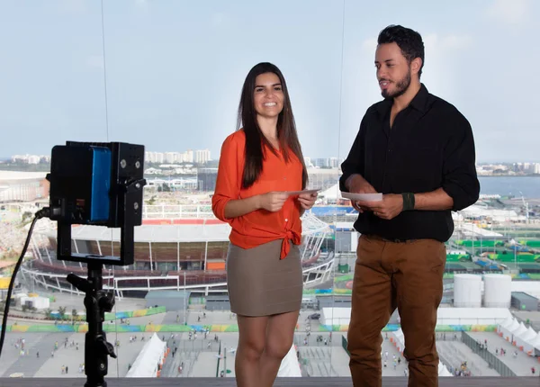 Presentador femenino latino y hombre caucásico en estudio de televisión — Foto de Stock